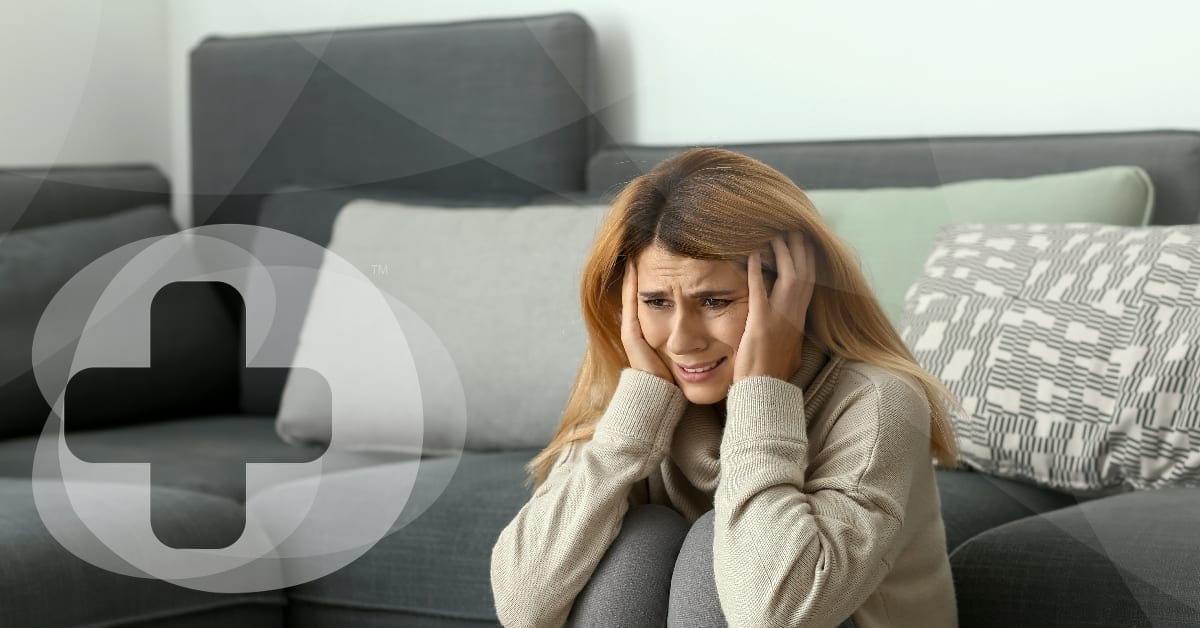 A lady sits on the floor having a panic attack