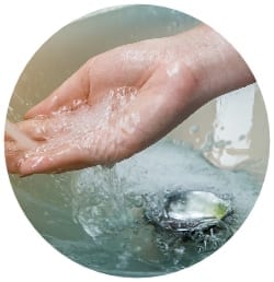 a hand being run under cold water after a burn.